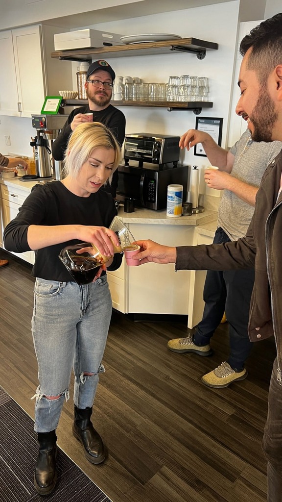Coffee Sommelier Savannah pouring coffee into a tasting cup for Alberto and others.