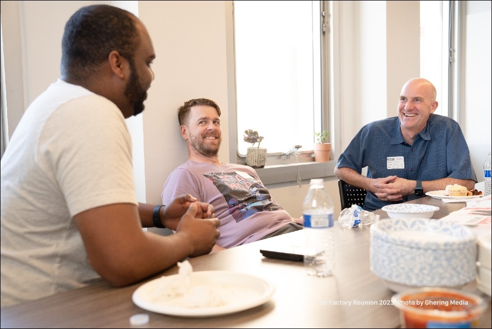 Three of our Factory community members enjoying a laugh at a table in one of our conference rooms
