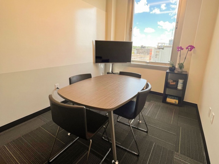 Our West Side conference room with 3 tables and tv next to a white board wall