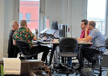 Four community members working at our tall table at The Factory